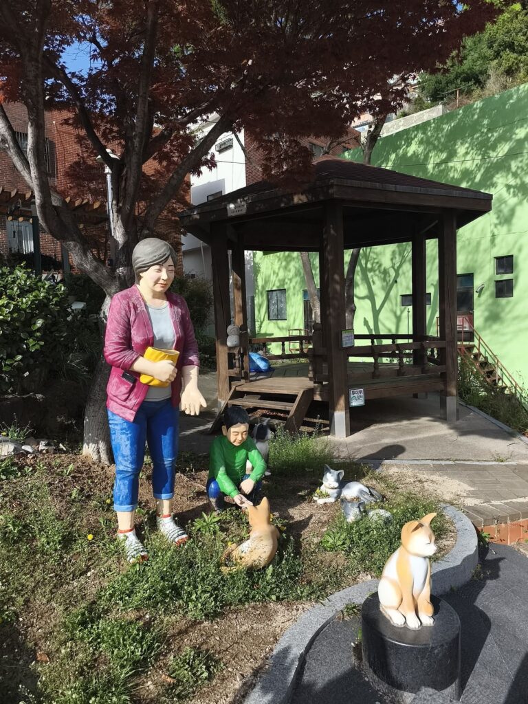 Small park with cat and people statues